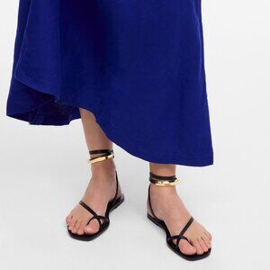 The Vira Bangle Ankle-Wrap Sandal in Leather, Black and gold
